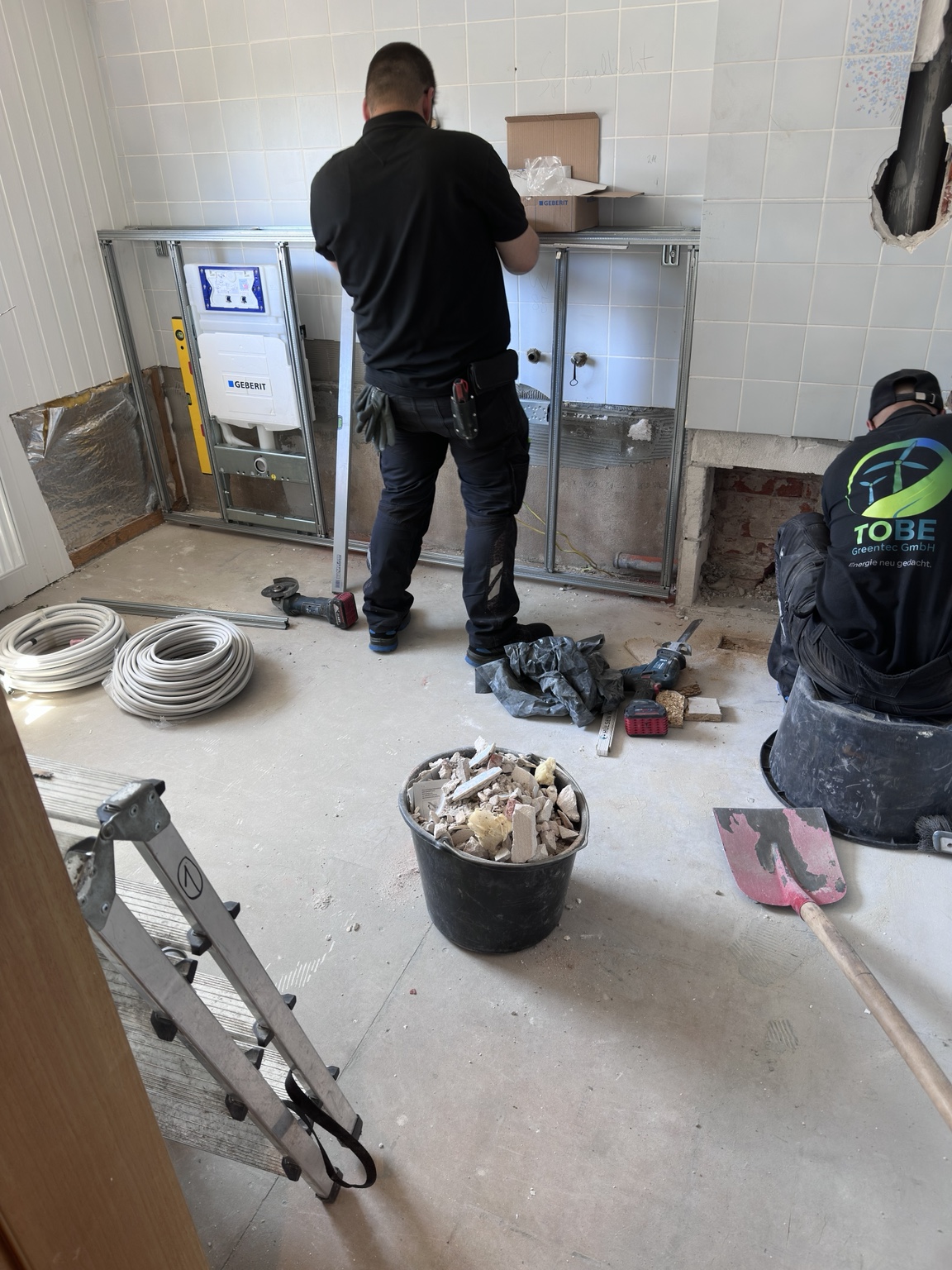 Zwei Mitarbeiter bei der Sanitärmontage mit Vorwandelementen in einem Bad